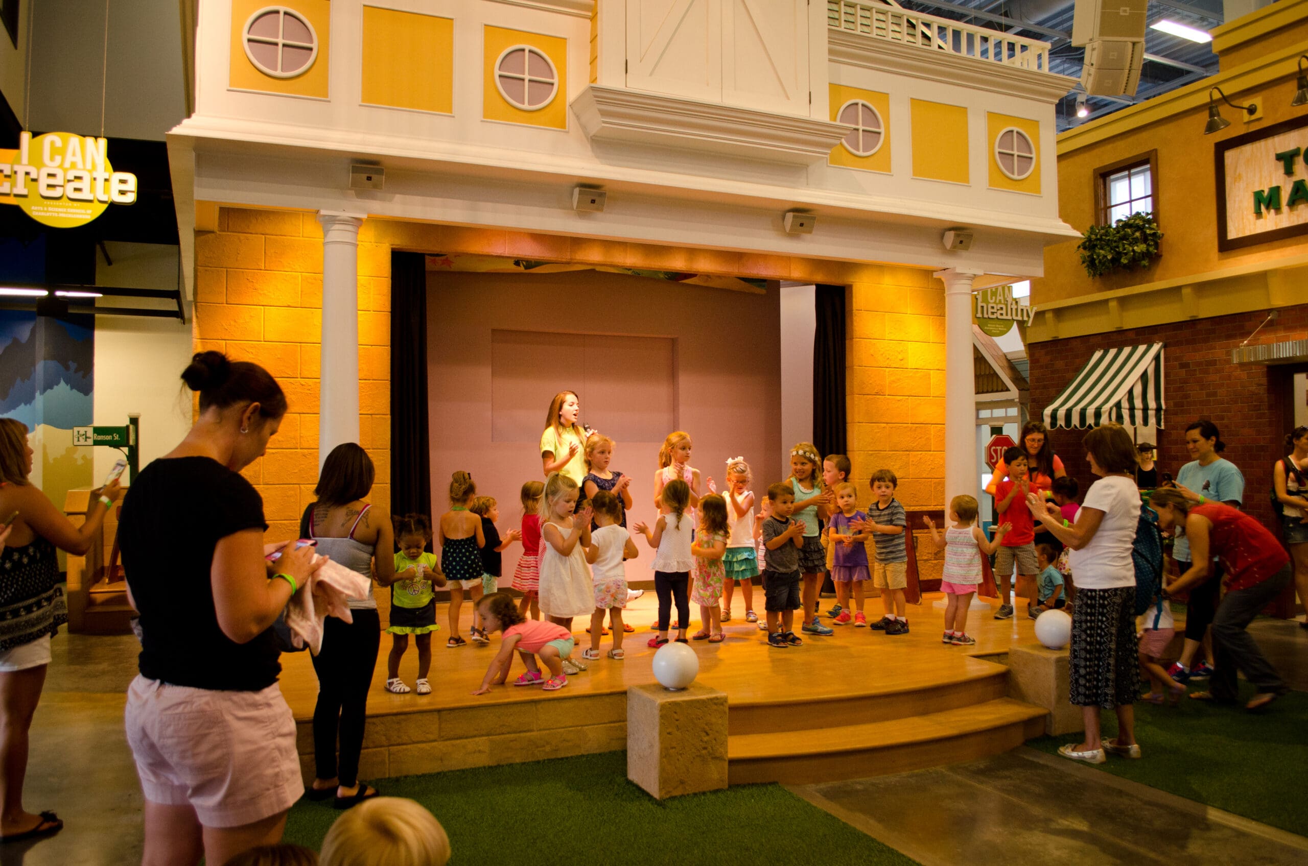 Children dancing at the Town Hall Stage in Discovery Place Kids Huntersville. Enjoy learning and activities when we celebrate Juneteenth at Discovery Place Kids.